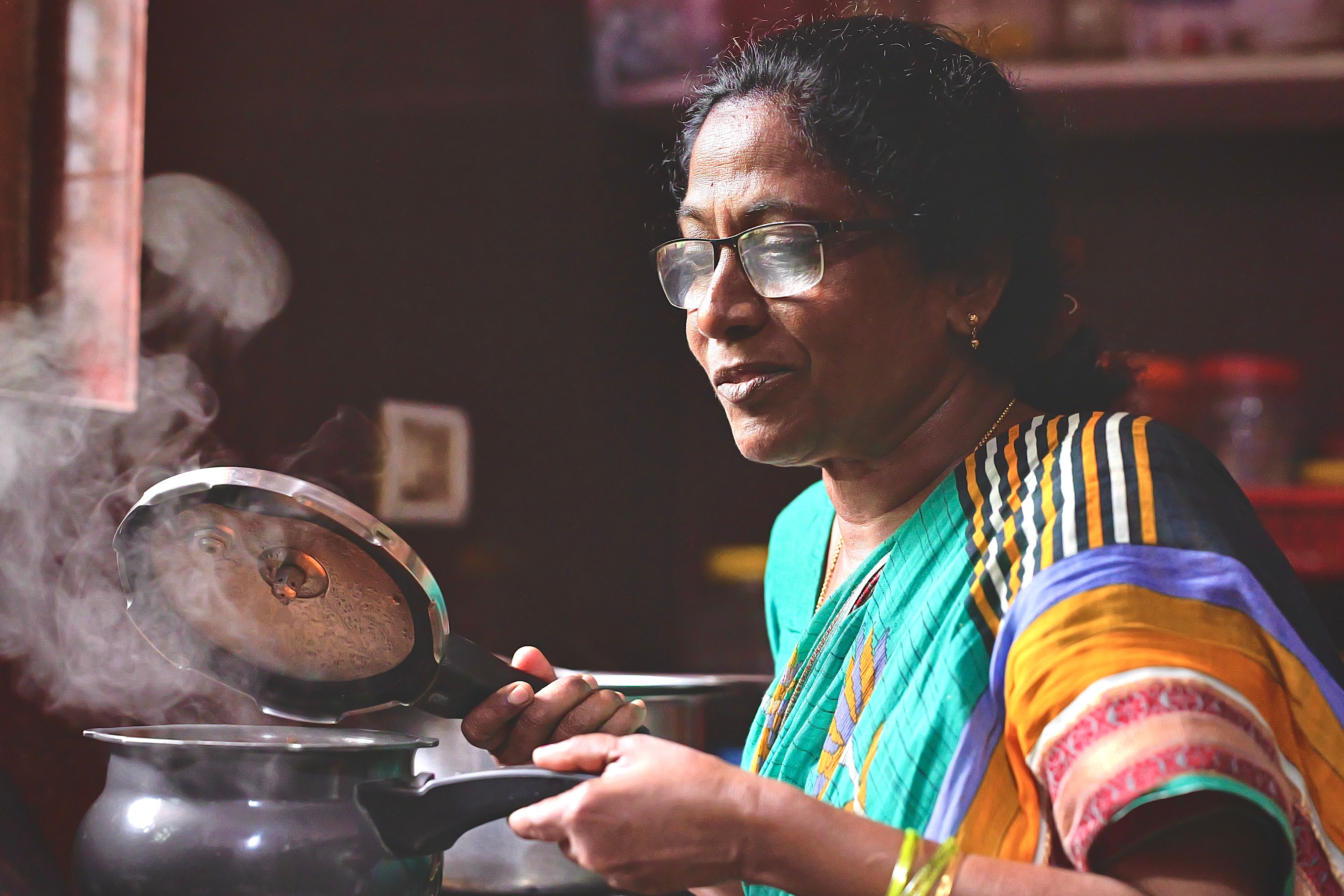 A woman smiling while she cooks