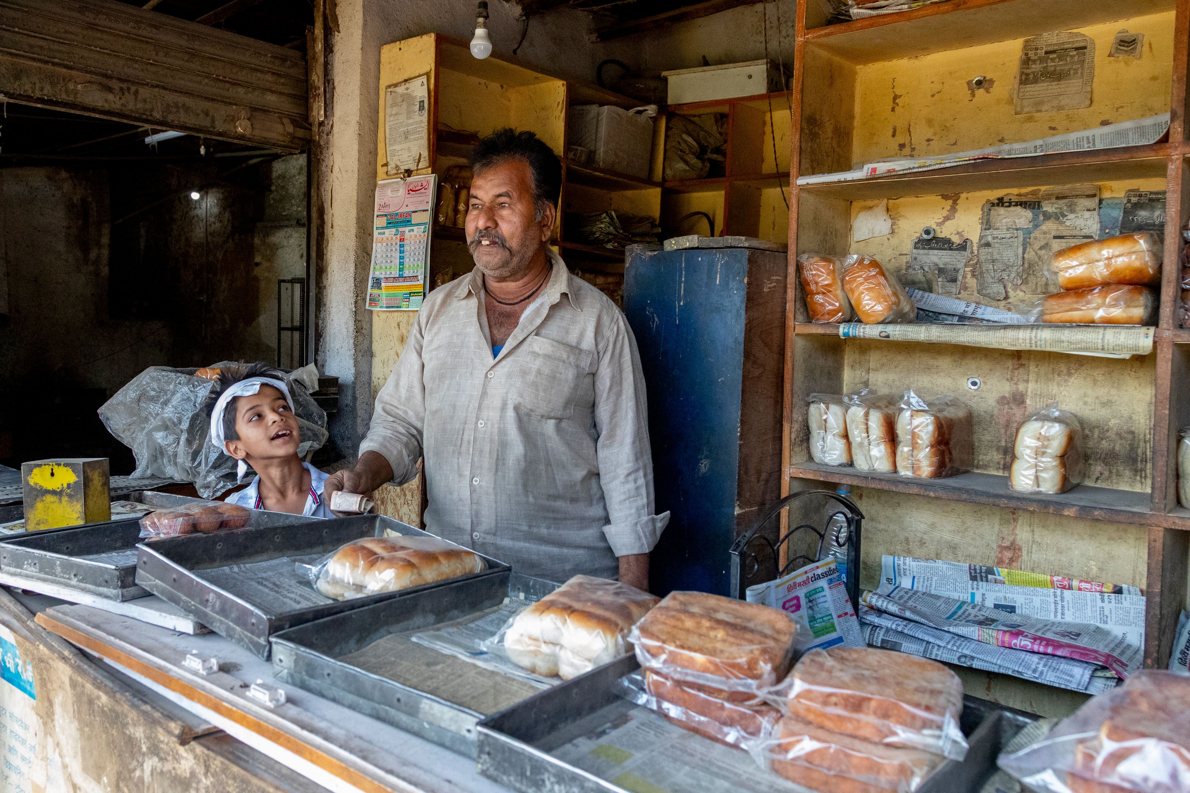 A baker behind the counter of his bakery shop