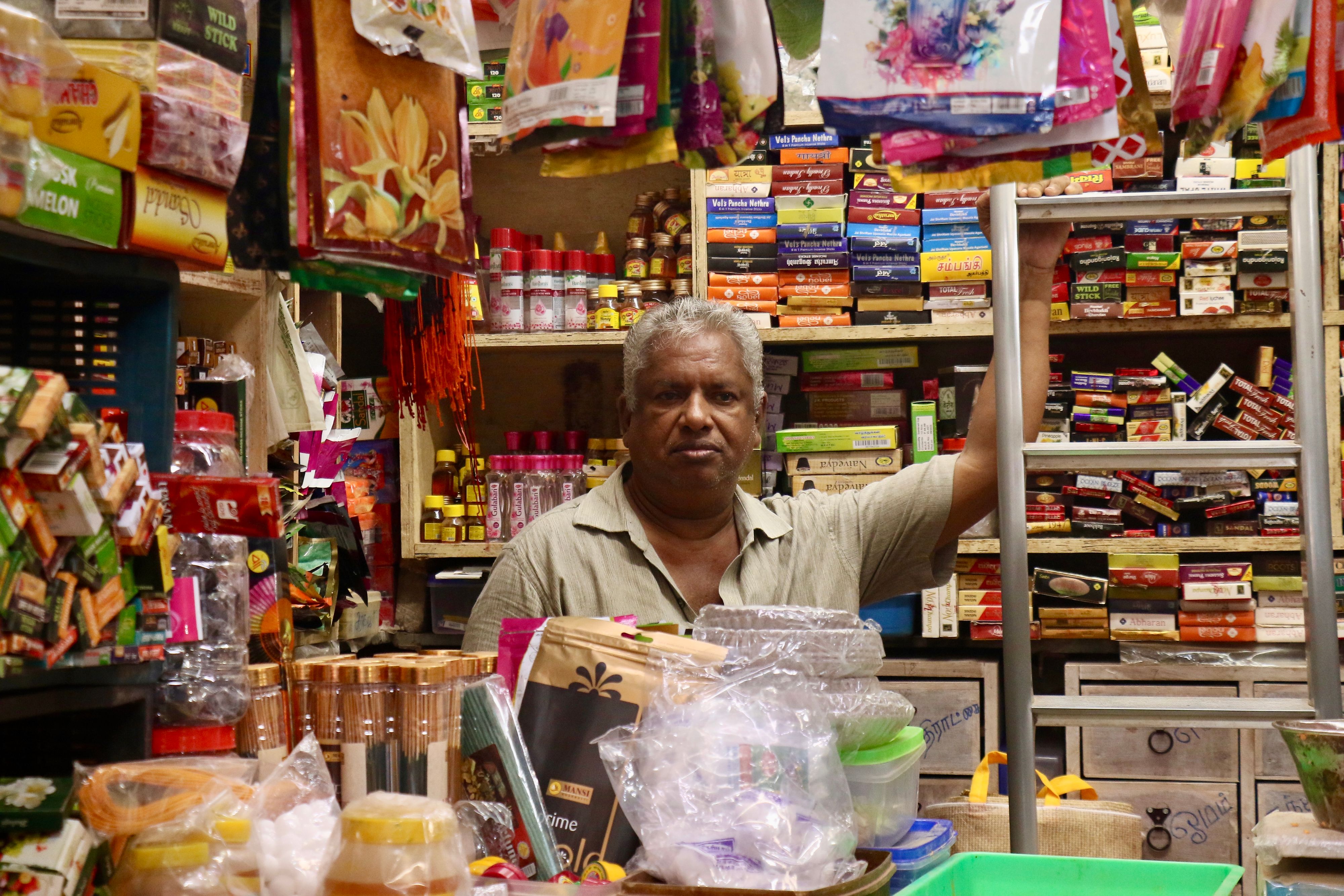 A shopkeeper in a busy neighbourhood grocery store